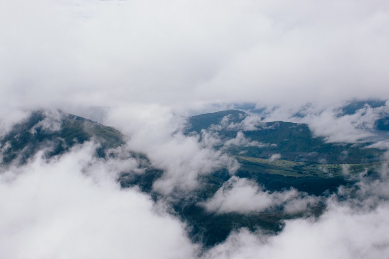 aerial view of the foggy atmosphere over mountains in scotland, scottish highlands under clouds 4k