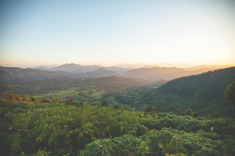 a lush tropical valley against a setting sun, sunrise over tropical valley 4k