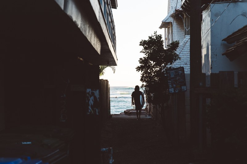 surfer walking through the alley towards the ocean, surfer walking in the alley 4k