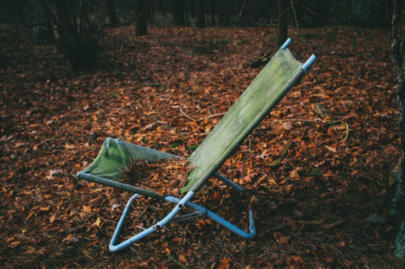 a large number of autumn leaves on an old deck chair in a forest, deck chair in an autumn forest 4k