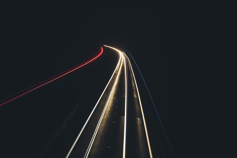 a long exposure shot of car lights glowing on a pitch black road in scunthorpe, traffic light trails in pitch dark 4k
