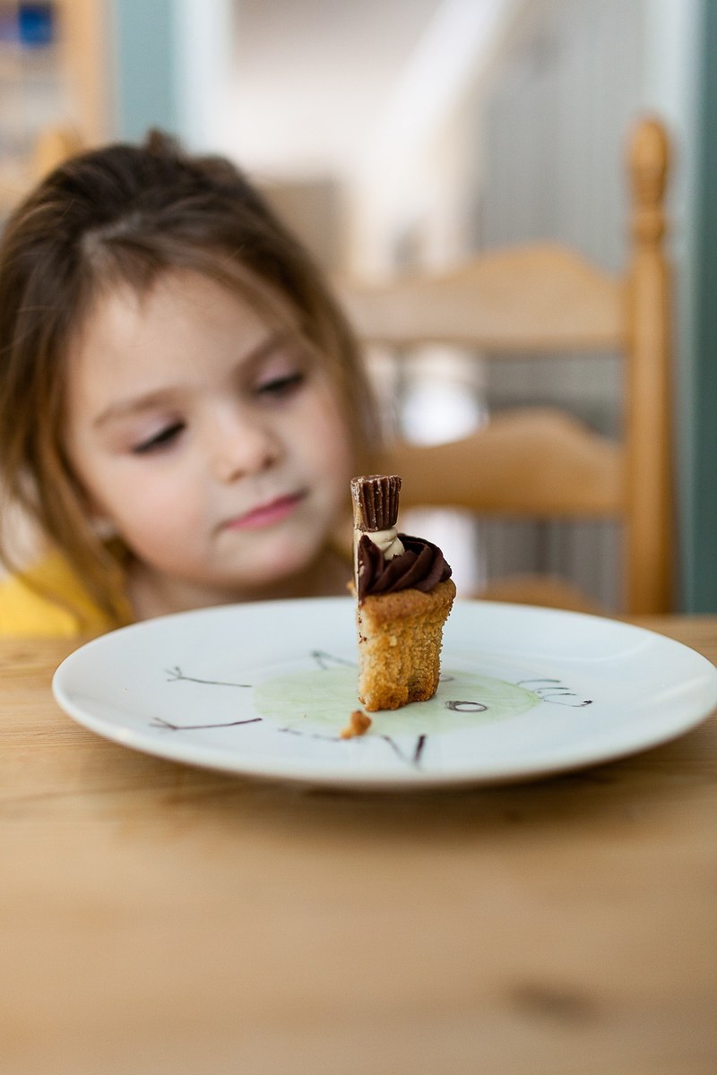 a little girl staring at half of a cupcake on a plate, kid friendly food 4k