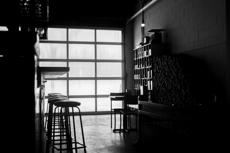 black and white shot of restaurant interior with stools counter and big wall window, monochrome inside restaurant 4k