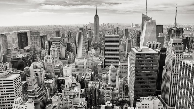 black and white photo of the downtown new york city skyline from top of the rock, a look across the island 4k