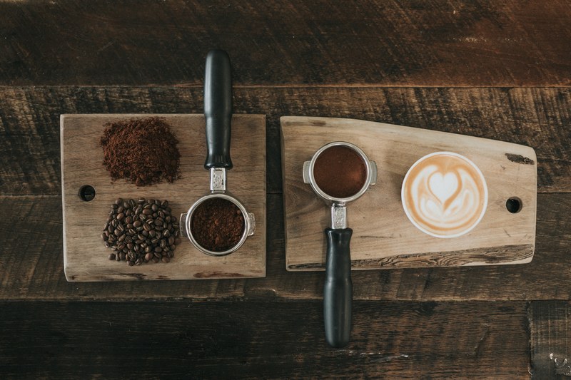 an overhead shot of two coffee machine portafilters next to coffee beans and a cup of coffee, latte deconstructed bar nine 4k