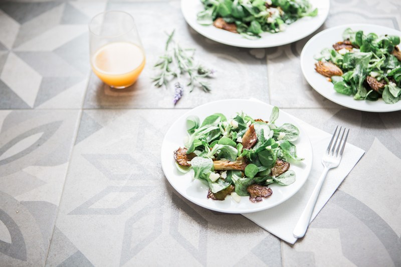 plates of fresh salads and a glass of orange juice at a kitchen table, salads for lunch 4k
