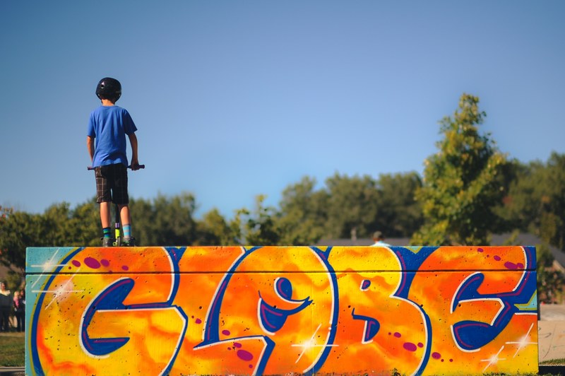 young child stands atop a graffiti ramp at a skate park, kid at the skate park 4k
