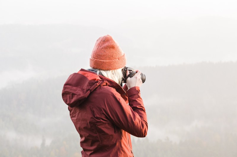 a woman photographing from on top of a mountain, _woman taking picture 4k