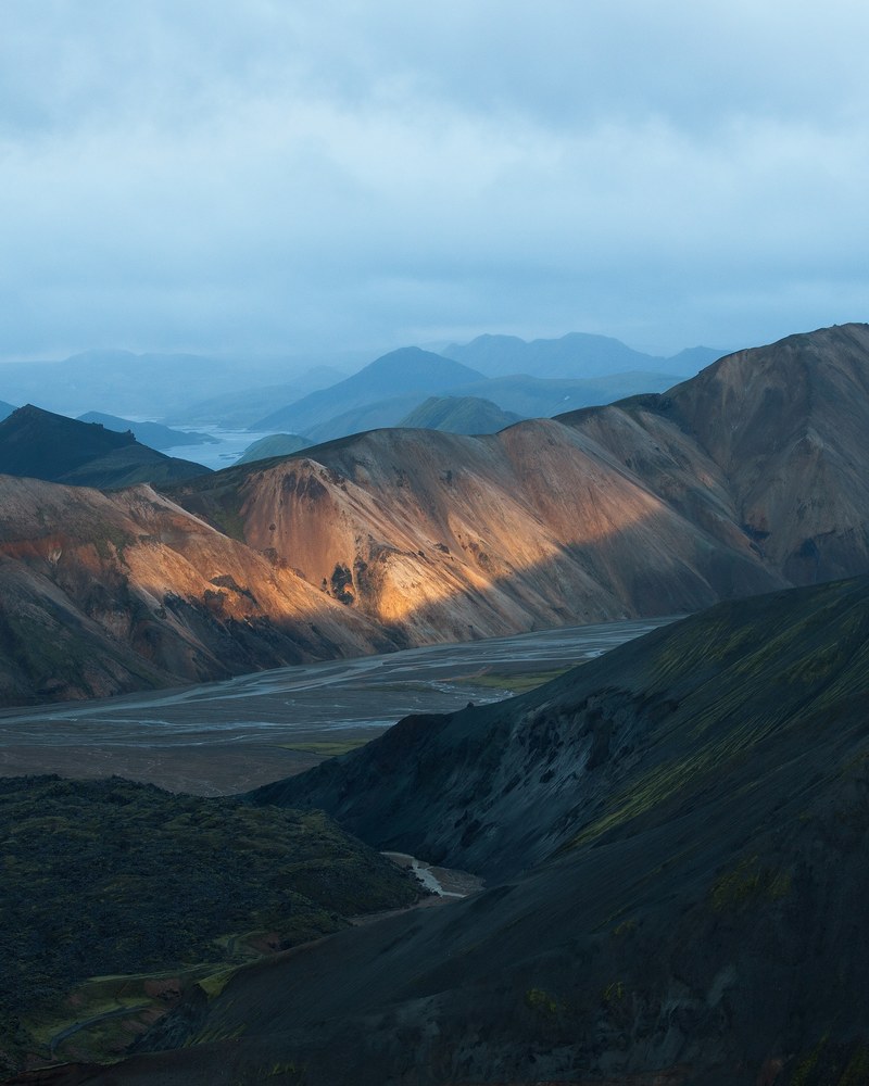 sunlight beams on desert mountains covered in fog, glacial valley 4k