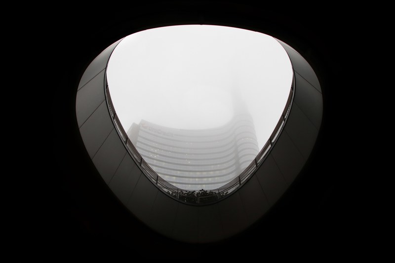 black and white shot from inside of building looking up at sky in milan, monochrome building roof hole 4k