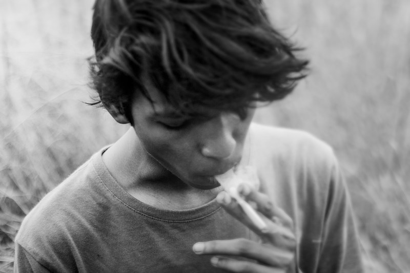 black and white shot of teen with long fringe smoking in rourkela, teen smoker in rourkela 4k