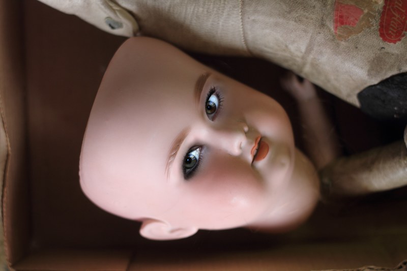 creepy doll face mask in a toy box, a real doll 4k