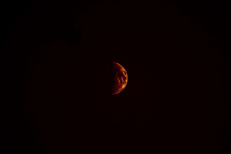 the half moon glows red in the sky over baltrum, half moon at baltrum 4k