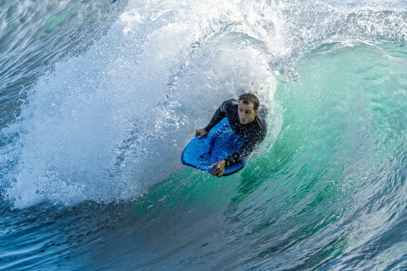surfer lying on the surfboard on the wave at north beach, laying surfer 4k