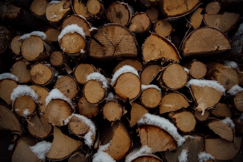 a pile of firewood covered in a thin layer of snow, firewood in the winter 4k