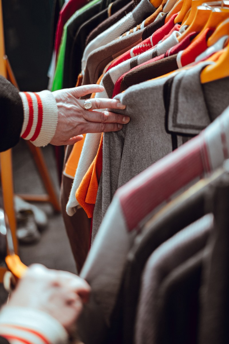 a person going through clothes at a store, _bargain hunt 4k