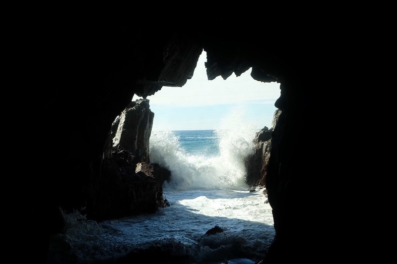 sea waves splashing at the entrance to a dark sea cave, sea cave entrance 4k
