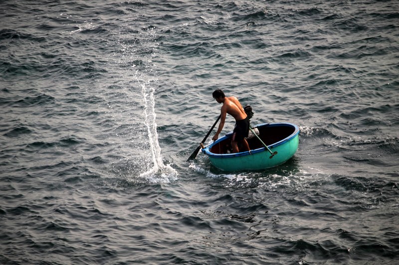 a fisherman paddling a turquoise boat in qung ngi, qung ngi fisherman boat 4k