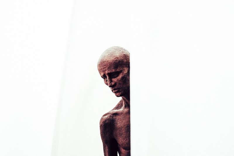 somber copper statue of a naked man at an art museum, hidden figure 4k