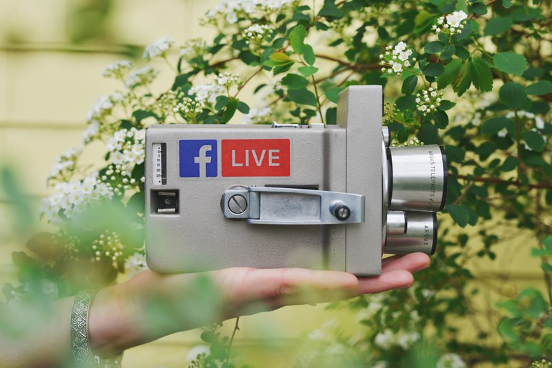 a hand holding a vintage video camera with stickers on it, analog 4k