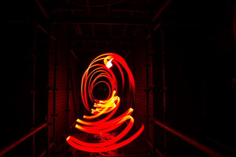 a long exposure shot of circles streaking from a bright red light trail, red circle light streaks 4k