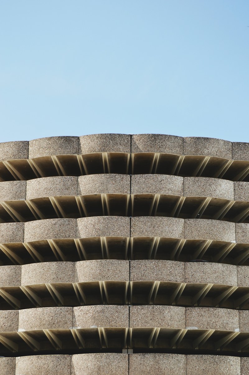 the concrete exterior of a multi story parking lot, sometimes 4k