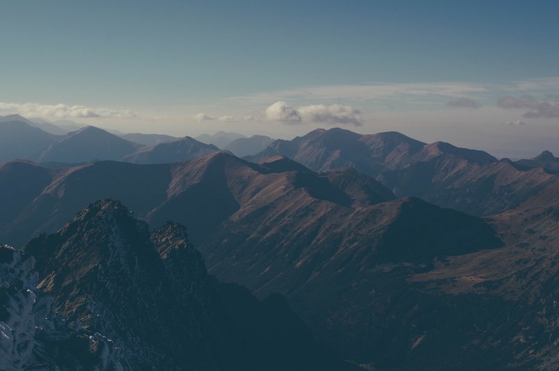 tall peaks and sharp ridges stretch to the horizon under a pale blue sky, tatra mountains landscape 4k