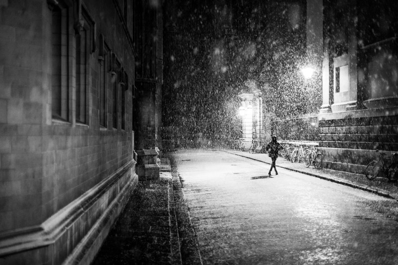 a person running across the street on a rainy night, running in the rain 4k