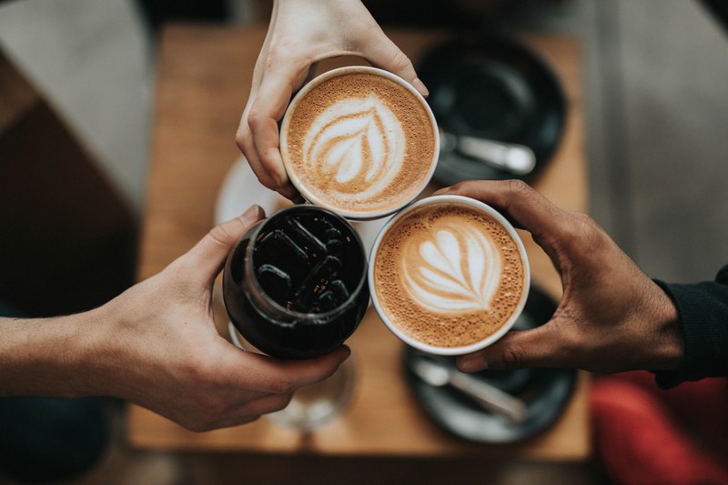 three people cheering with iced coffee and lattes at verve coffee, coffee and friends 4k