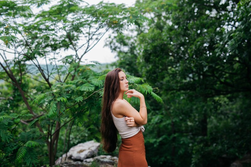 woman standing alone thinking near forest trees, thinking in nature 4k