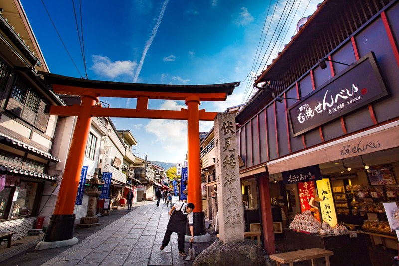a torii gate over a store lined street in japan, travel in osaka 4k