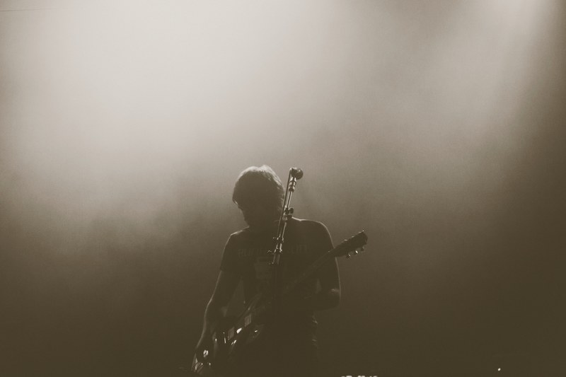 a black and white shot of a guitarist performing at a concert, monochrome guitar player 4k