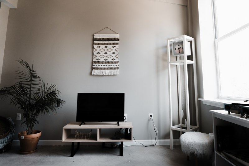 living room with gray walls a tapestry television and clock in the corner near a window, relax 4k