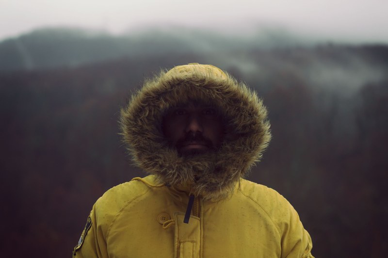 portrait of a man in furry hooded coat on a cold wooded walk, bundled up 4k
