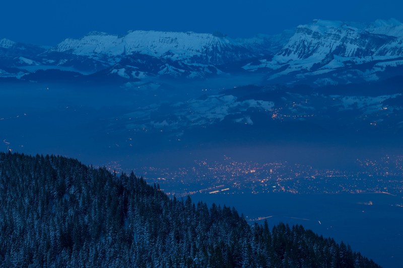 forest slopes and snowy mountains overlooking the town of thun on an inky blue night, thun at dusk 4k