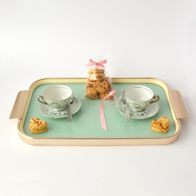 a tray with two teacups on saucers and a bag of cookies on a white surface, tray with teacups and cookies 4k