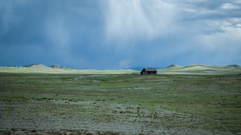 a bleak landscape with a wooden cabin on a desolate plain, lonely cabin 4k