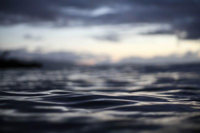close up of the dark ocean waters of waimea bay under a cloudy sunset, close up of waimea bay ocean water 4k