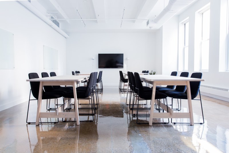 a boardroom with several tables and a television on the wall, tables in a boardroom 4k