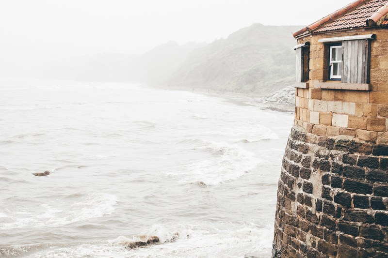 brick building on the sea shore on a foggy morning, escape to the seashore 4k