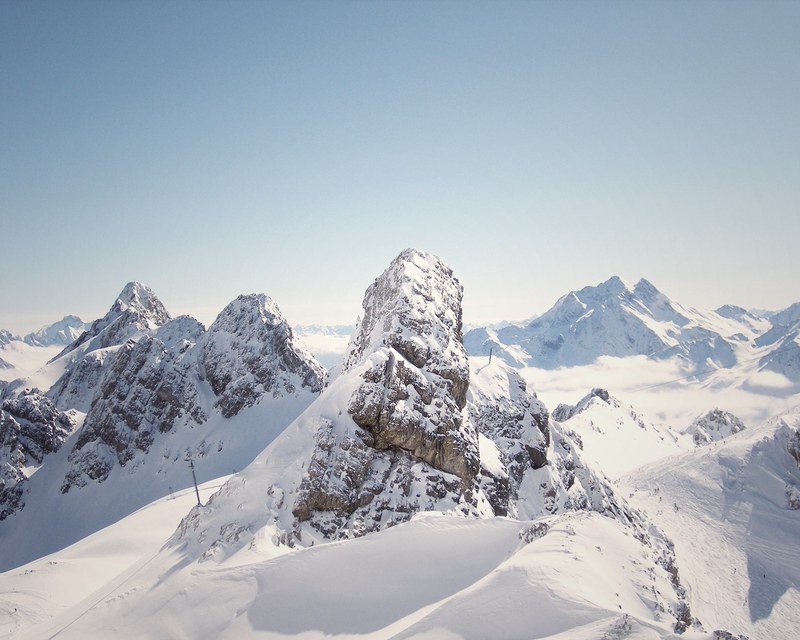 a mountainscape background photo capturing snowy hills and rock formations, winter in the wilderness 4k