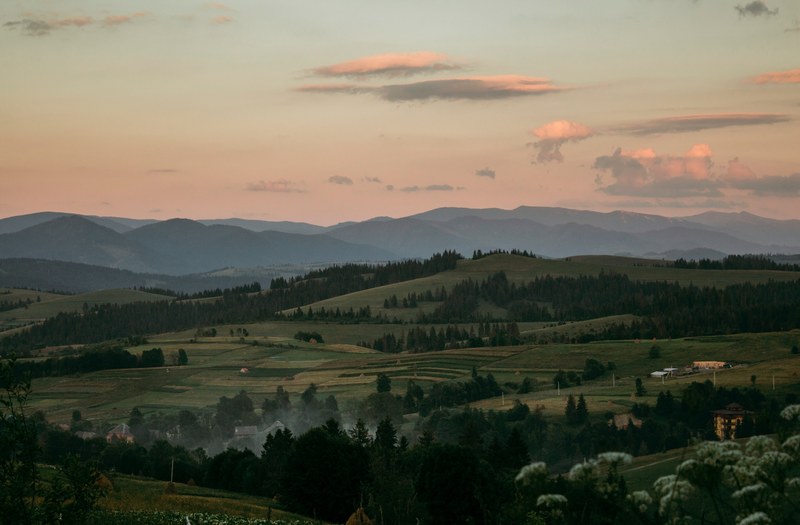 a rural landscape stretching along undulating hills in the carpathian mountains, sunset 4k