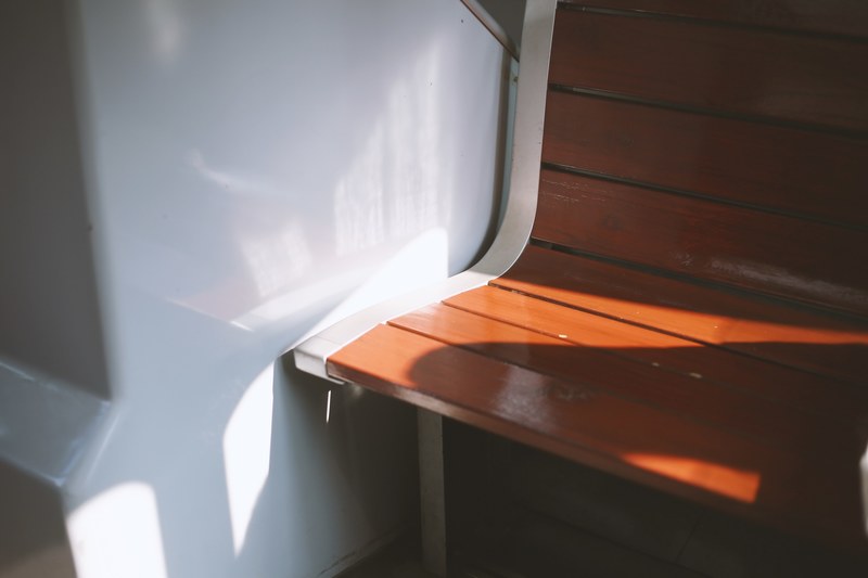 empty public bench made of wood, shadows 4k