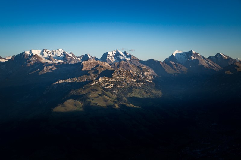 sharp mountain ridges with snow topped peaks against a blue sky in niesen kulm, swiss alps under a blue sky 4k