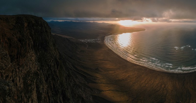 view from a mountain on a green ocean coastline in lanzarote, mountain view on coastline 4k