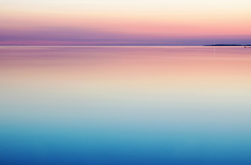 a peaceful and serene pastel pink and purple sunset reflecting on still and calm water, sunset water sea and colorful 4k
