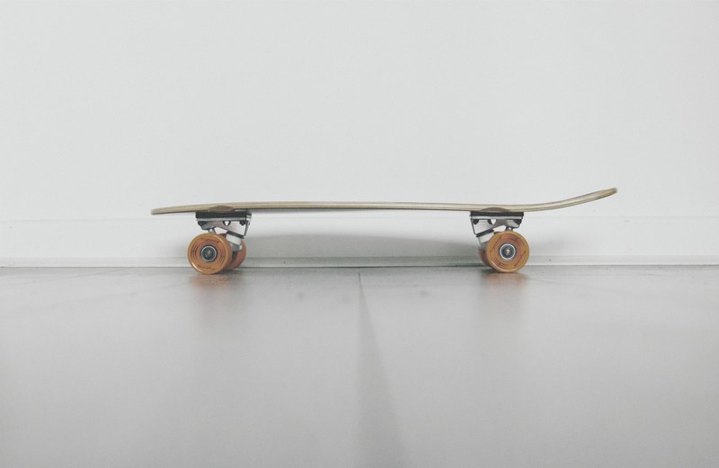 a low shot of a skateboard near a white wall, skateboard near a wall 4k