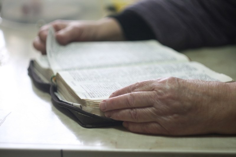 a person turning the page of an open book, _man reading through book 4k