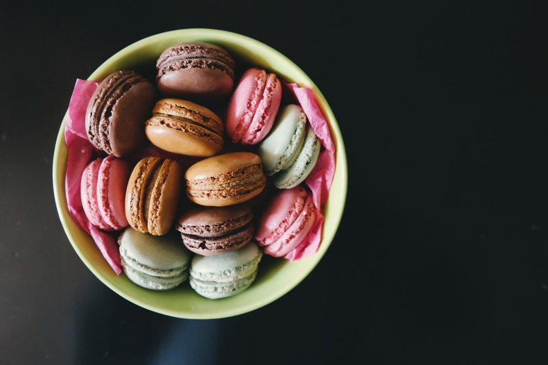 colored cookies with frosting in the middle sitting in a bowl, _bowl frosted cookies 4k