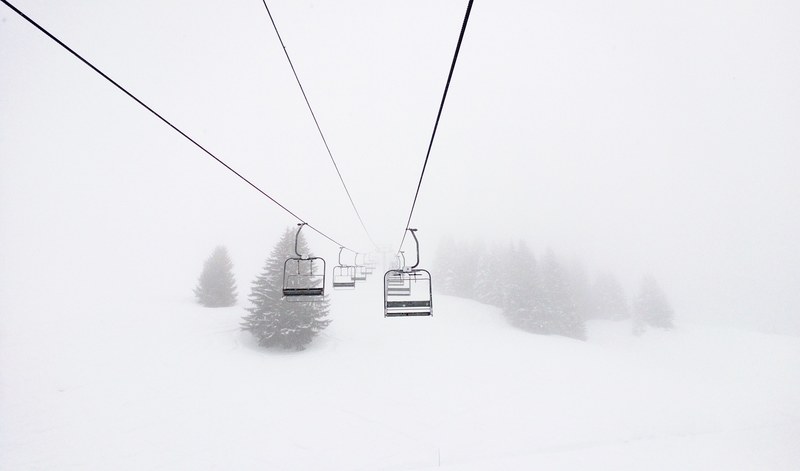 chairlifts on a snowy ski slope in morillon, misty ski lifts 4k